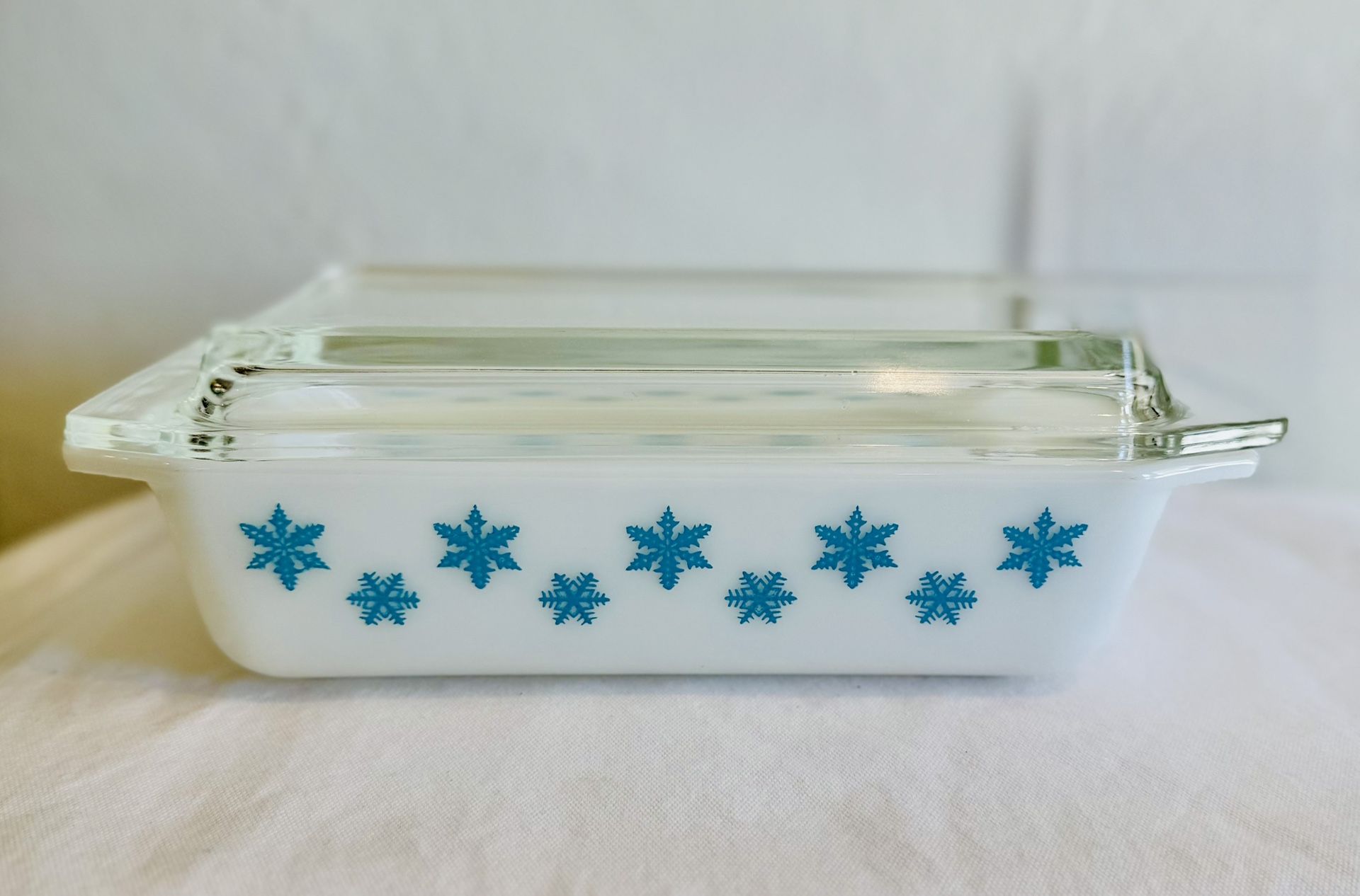 vintage Pyrex Turquoise Snowflake casserole dish with a clear glass lid.