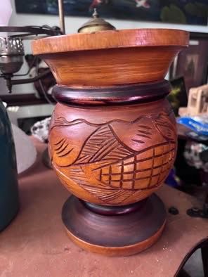 vintage hand-carved wooden vase with decorative geometric or tropical motifs.