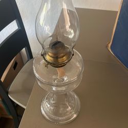 Antique clear glass oil lamp with a burner and chimney. 