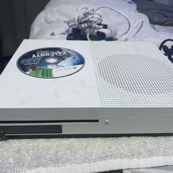 Microsoft Xbox One S console with a physical game disc, specifically Call of Duty: Black Ops, inserted. 