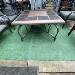 Patio set: a table with a fire pit and four comfortable chairs—all in good condition.