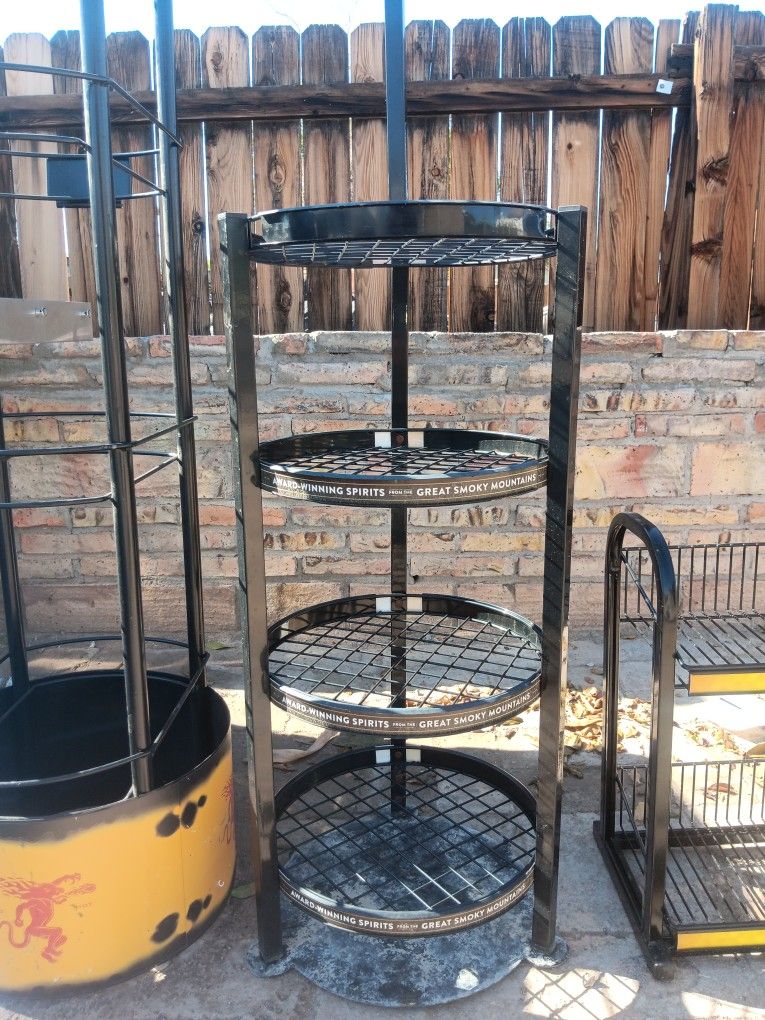 All black round rack with the wheels on the bottom.