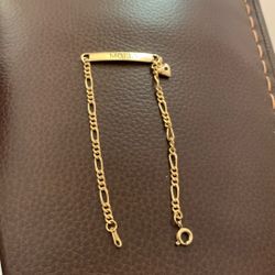 personalized gold identification (ID) bracelet with the name "MOLLY" engraved on the nameplate and a heart detail near the clasp.