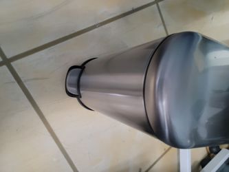 Small stainless steal and black metal trash can w/ pedal lid