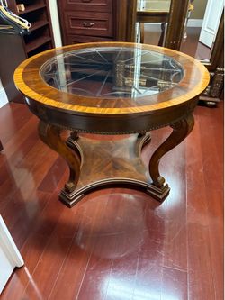 This round accent table features a mahogany-finished base and a glass top with decorative etching
