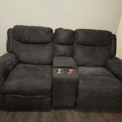 Grey reclining loveseat with center console and power outlets