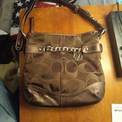 This is a Coach F19730 signature canvas and leather crossbody shoulder bag in brown with silver-tone hardware