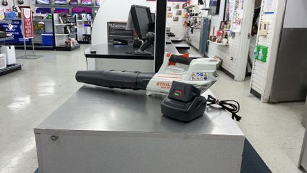 Stihl BGA 56 cordless battery-powered handheld leaf blower paired with a charger
