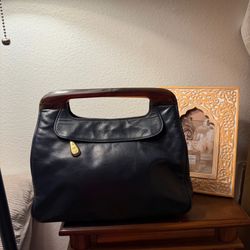 Vintage navy blue leather handbag is from Anne Klein