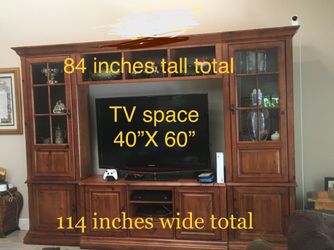 Walnut-finish entertainment system with lots of storage, display space, and room for huge flatscreen TV.