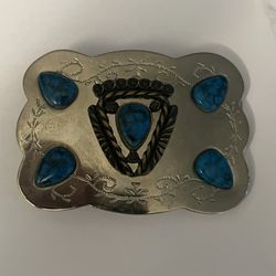 vintage 1980s Southwest-style belt buckle is constructed from silver-plated metal and features faux turquoise stones. 