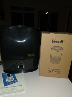 Compact Levoit Core Mini-P air purifier in white and a black ultrasonic humidifier. This set includes the original box for the air purifier and the us