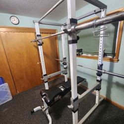 TUFF STUFF Squat rack and adjustable weight bench with Olympic barbell.