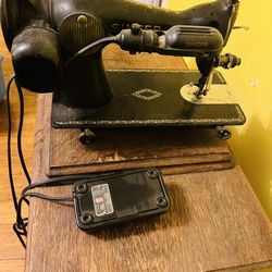 vintage Singer treadle sewing machine with electric motor and wooden cabinet