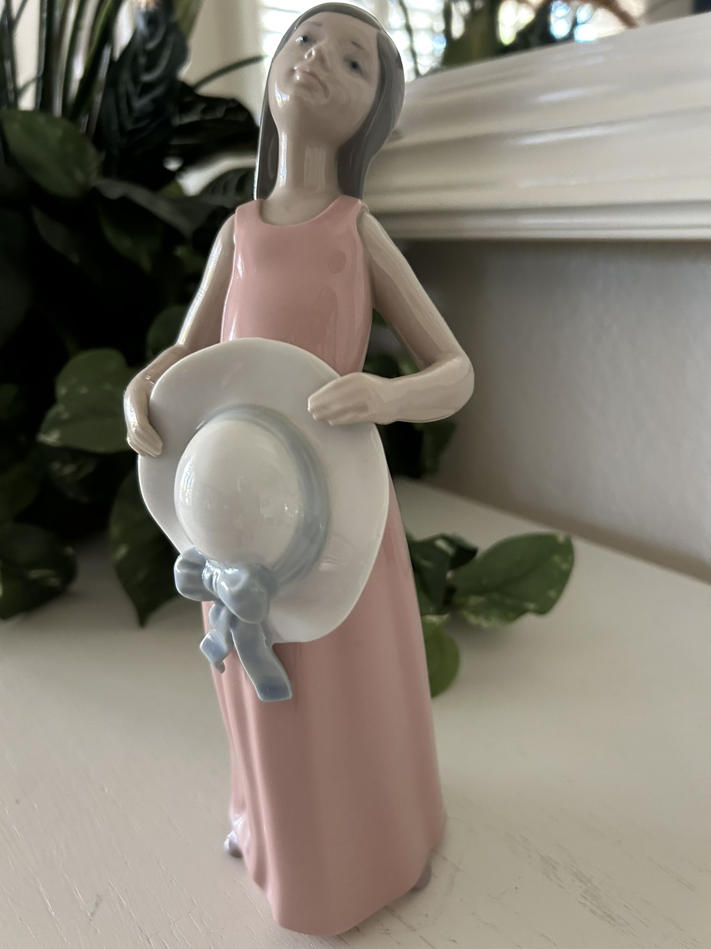 The product is a Lladro "The Dreamer" or "Curious Girl with Straw Hat"