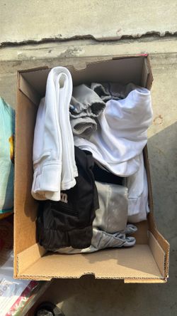 Box of men’s and kids used practice baseball pants.