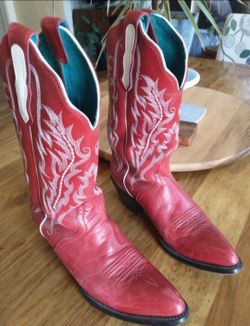 Stylish red cowboy boots with intricate white stitching.