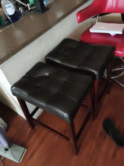 2 brown leather bar stools