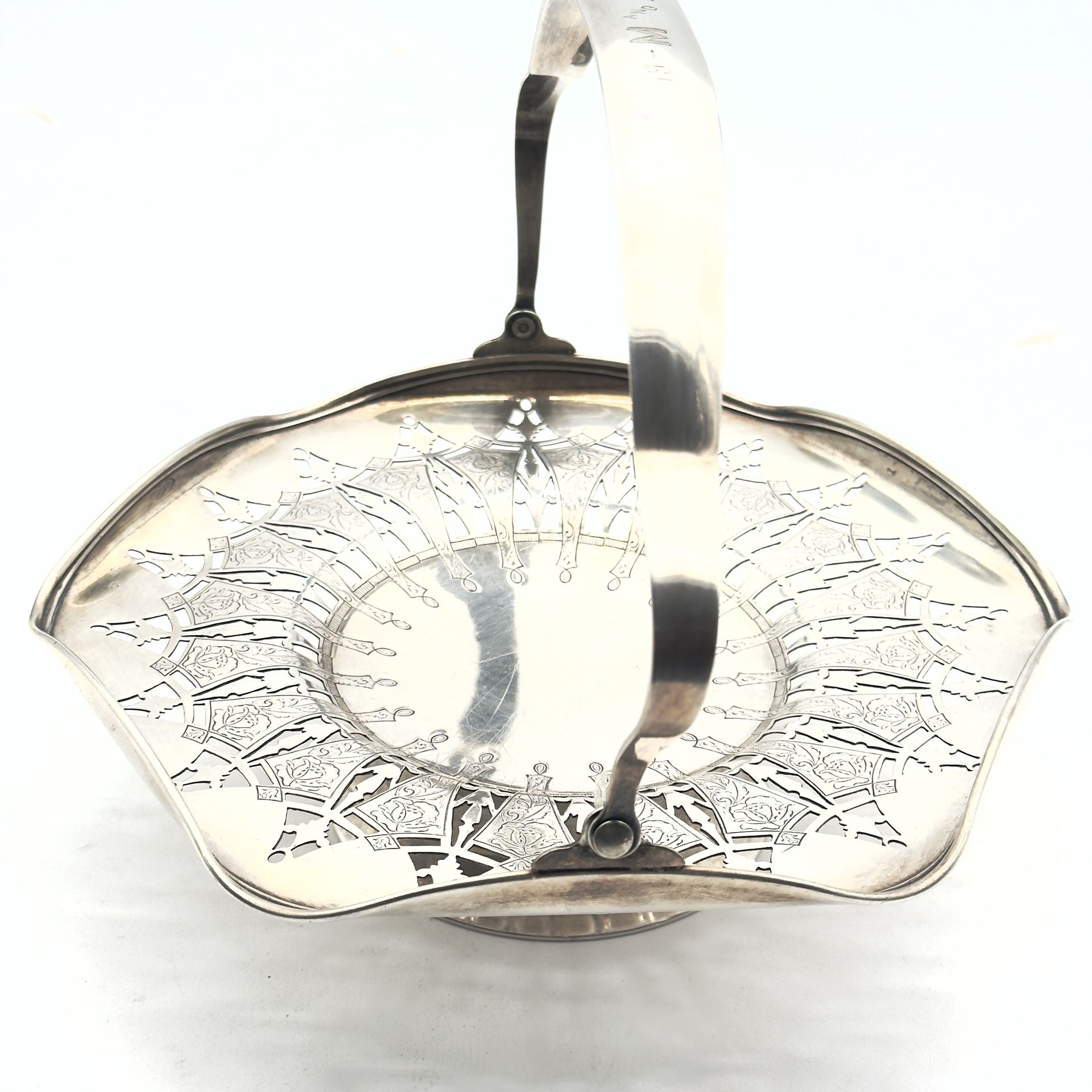 The product is an antique silver plated cake fruit basket with a swing handle on a pedestal, manufactured by Wm. Rogers & Son in the United States in