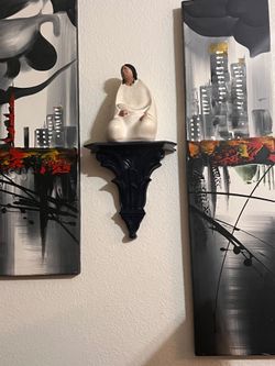 White Ceramic Figurine on Black Wall Bracket