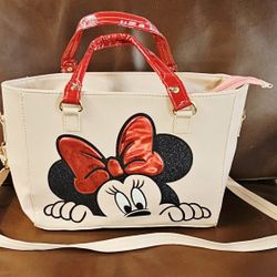 Disney Minnie Mouse handbag or tote bag featuring a prominent graphic of Minnie Mouse's face and bow. 