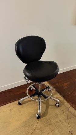 Chair on wheels, tattoo armrest, semi-circular lamp