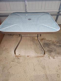 Glass topped patio table with 4 chairs