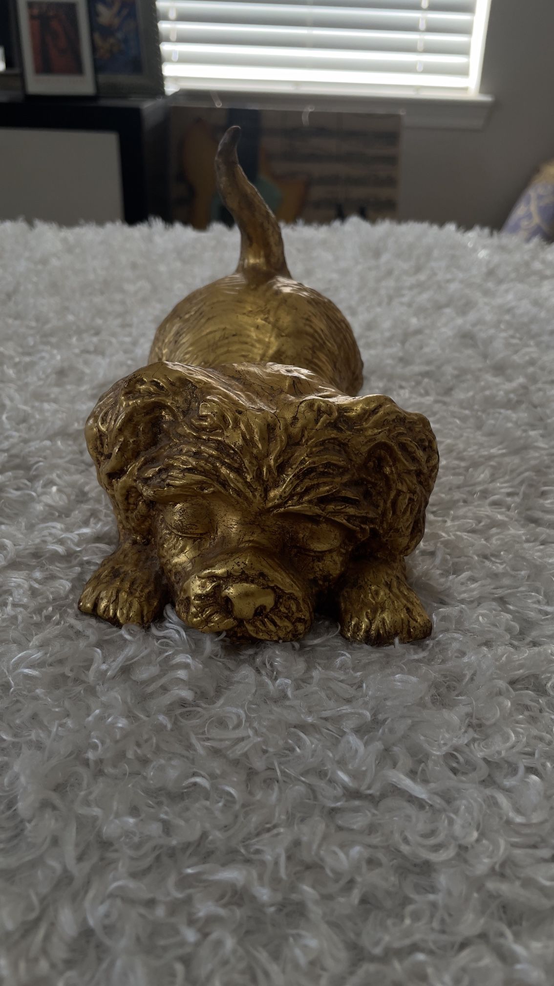 Vintage gold-colored sculpture of a Yorkshire Terrier puppy in a playful pose.