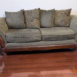 Heavy duty sofa with pillow styled with hard wood arms