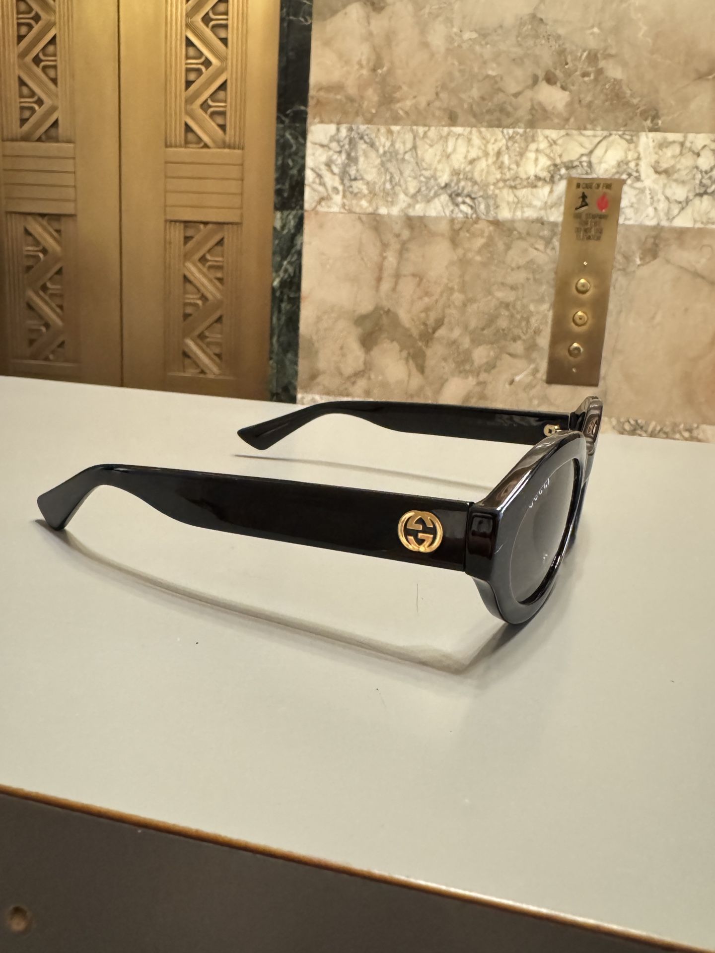 Gucci Oval Shiny Black and Gold Sunglasses display picture 1