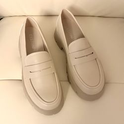 These shoes are Cesttini loafers in an off-white color, known for their classic and elegant design. Size 8