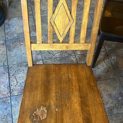 Beautiful solid wood dining chairs with a rustic farmhouse style. Each chair features a unique design, including decorative backs and rich wood tones 