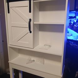 One sliding barn door LuxenHome Farmhouse White Over-The-Toilet Space Saver Cabinet
in a farmhouse style with black hardware.
The space saver is 27.2 