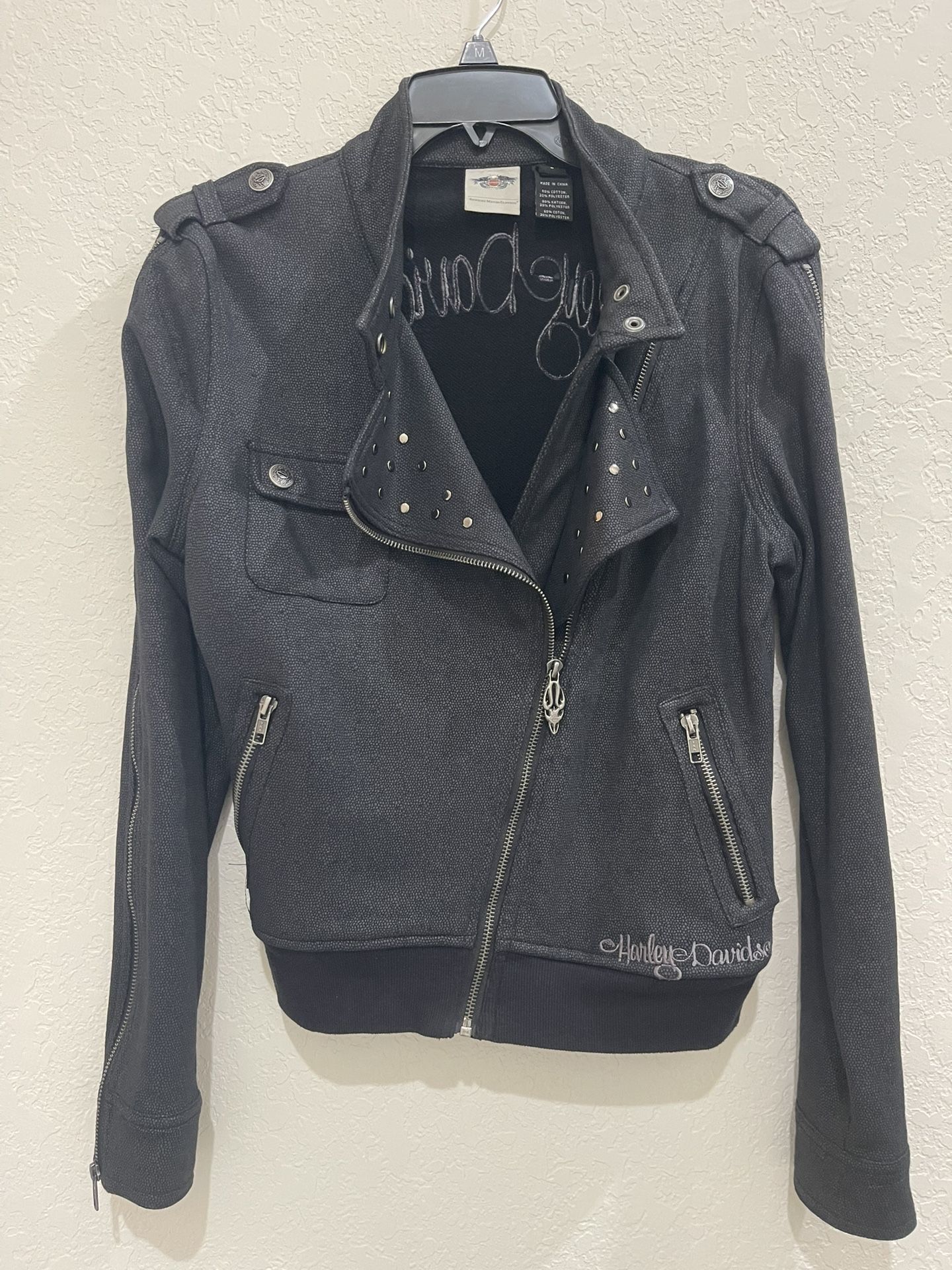 Authentic Harley Davidson Women’s Non-leather Zippered Jacket. Angled zippered closure with neckline snaps.  Studded. Zippered Sleeves. Full 1903 logo