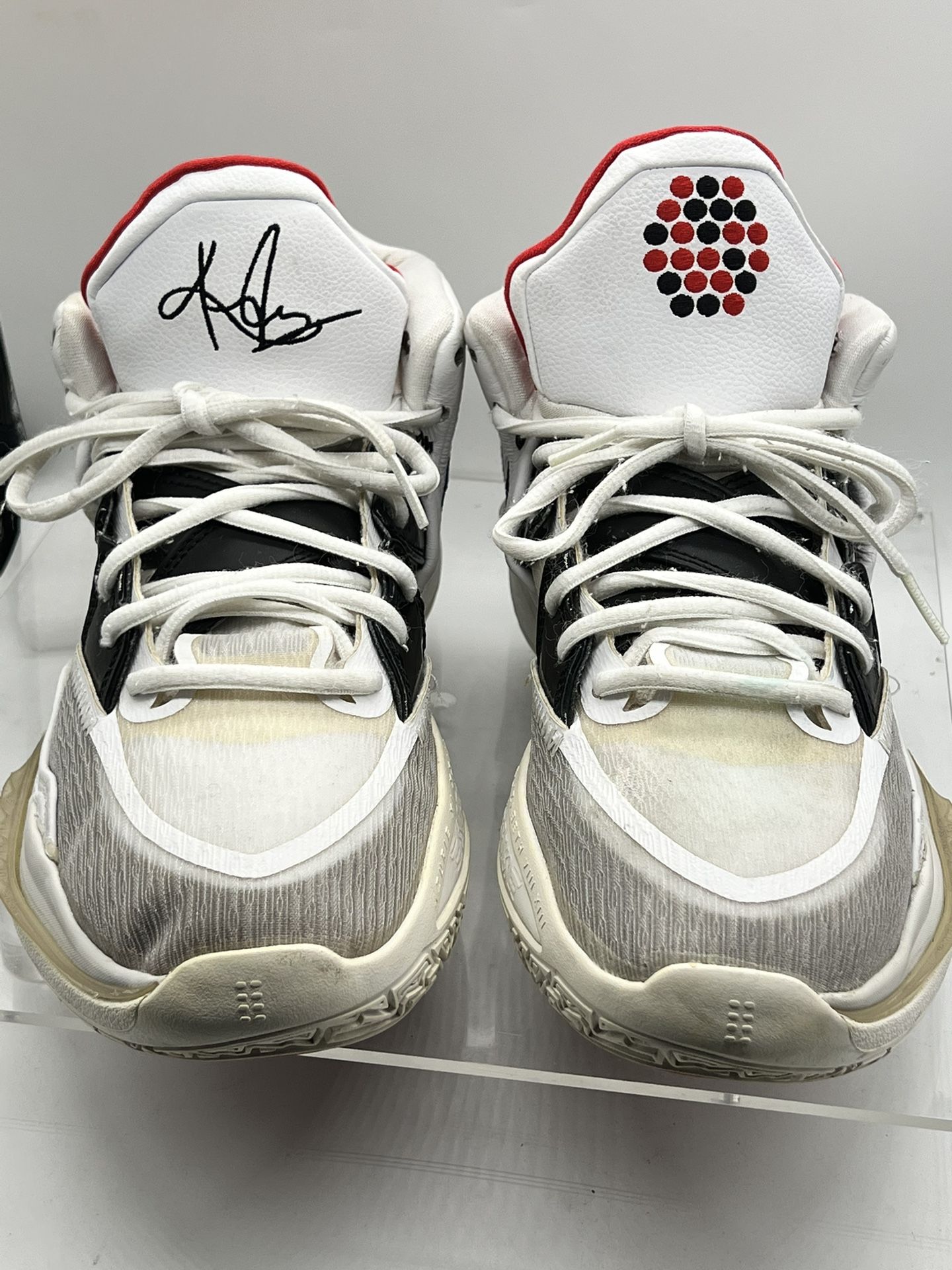 Stylish basketball sneakers with a unique signature design. Features a white and black color scheme with red accents. Perfect for sports and casual we