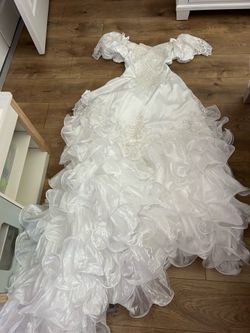 white wedding dress features a sweetheart neckline, off-the-shoulder lace sleeves, and a voluminous skirt covered in numerous ruffled layers size smal