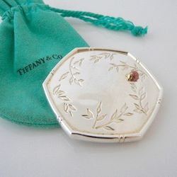Authentic Tiffany & Co. compact purse mirror crafted in sterling silver with gold bamboo motif and a raised ladybug accent. Octagonal shape. Elegant n