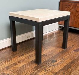 Crate and Barrel side table with a travertine top and black metal base.