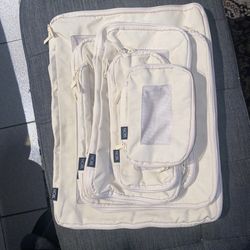 NOBL packing cubes in a light color, likely beige or off-white, made from a fabric like nylon or polyester blend. 山