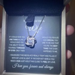 This is a 925 silver-toned love knot necklace with a crystal pendant