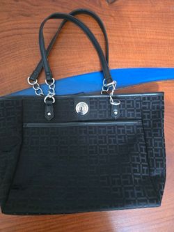 Elegant black tote with subtle Tommy Hilfiger logo pattern and chain-link strap accents. Lightweight and versatile for everyday use. Clean lines and a