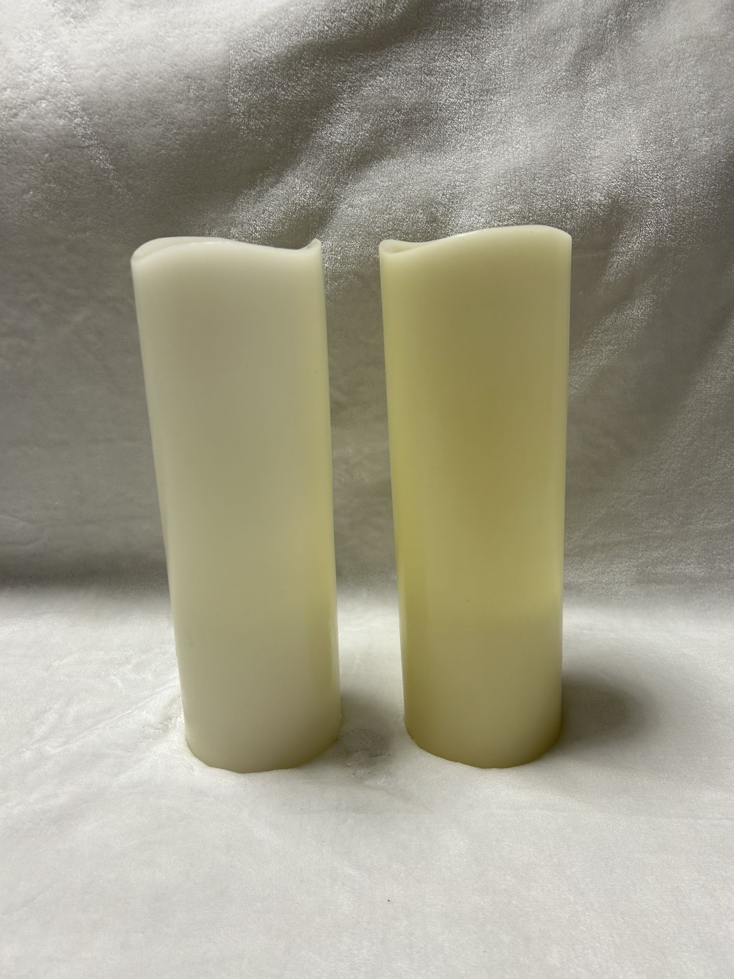 Two white 12 inch tall flameless battery operated pillar candles