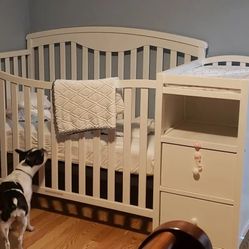 Crib with changing station, mattress, changing station cushion, and side compartments with drawers