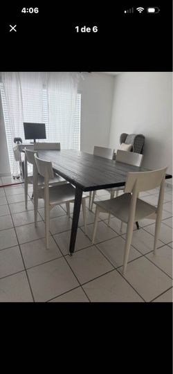 Modern rectangular dining table with a dark wood-look textured top and sleek black metal legs. Spacious design comfortably accommodates 6 chairs. Clea