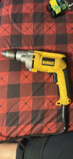 Yellow DeWalt drill with cord. Has some signs of wear. Works as expected. 