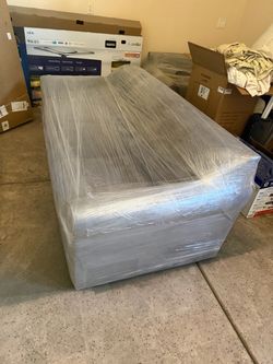 Couch and loveseat with new cover wrapped in plastic