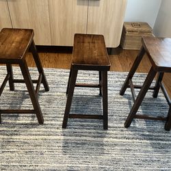 Three dark bar stools