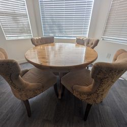 Round wood dining table with 4 tufted chairs