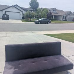 Dark Blue Futon/Sofa Bed. Modern style with velvet-like fabric and chrome legs. Sleek, armless design folds flat for guests. Great condition! 