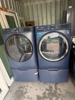GE Sapphire Blue front-load washer and dryer set with pedestals.